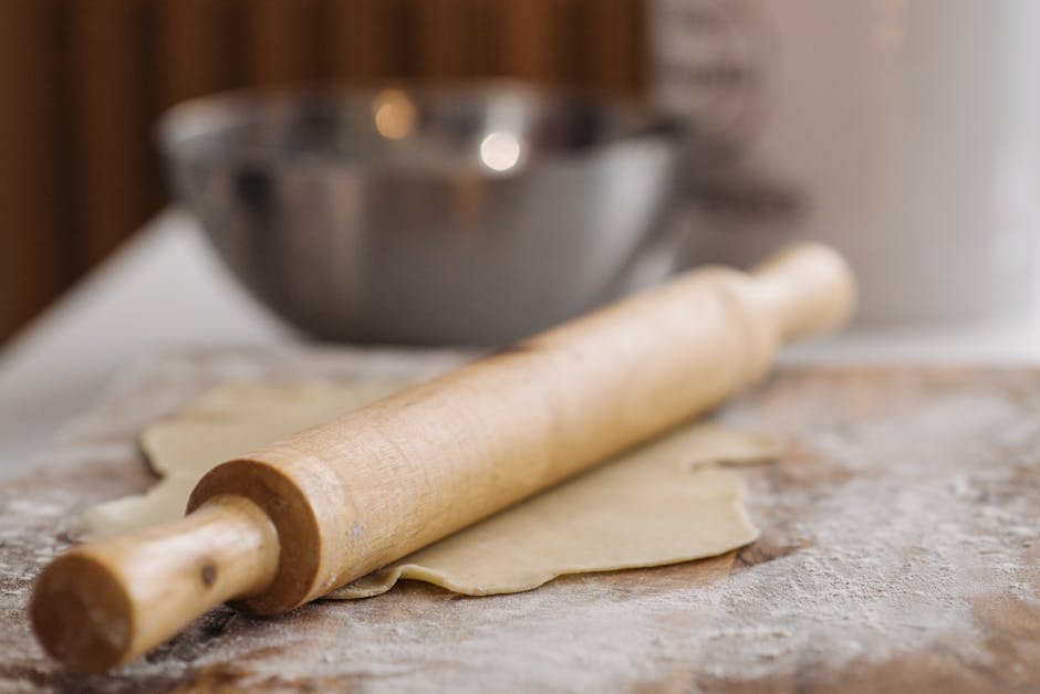 Pâte à tarte étalée au rouleau sur un plan de travail fariné